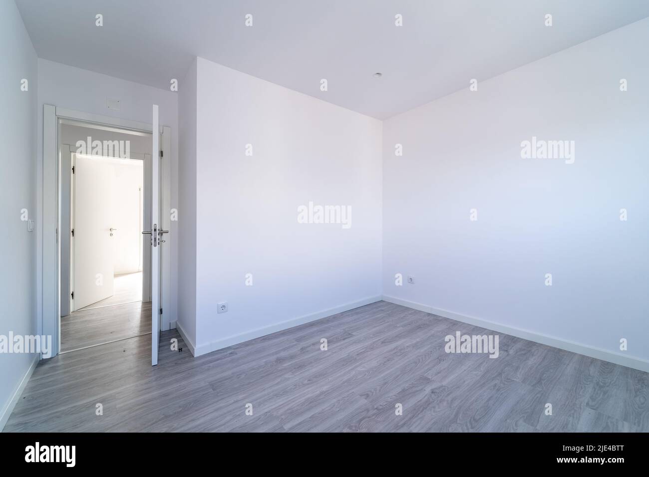Empty room with gray wooden floating, laminate flooring. House interior, wide bedroom or living room space. New home, apartment or house. Wood floor. Stock Photo