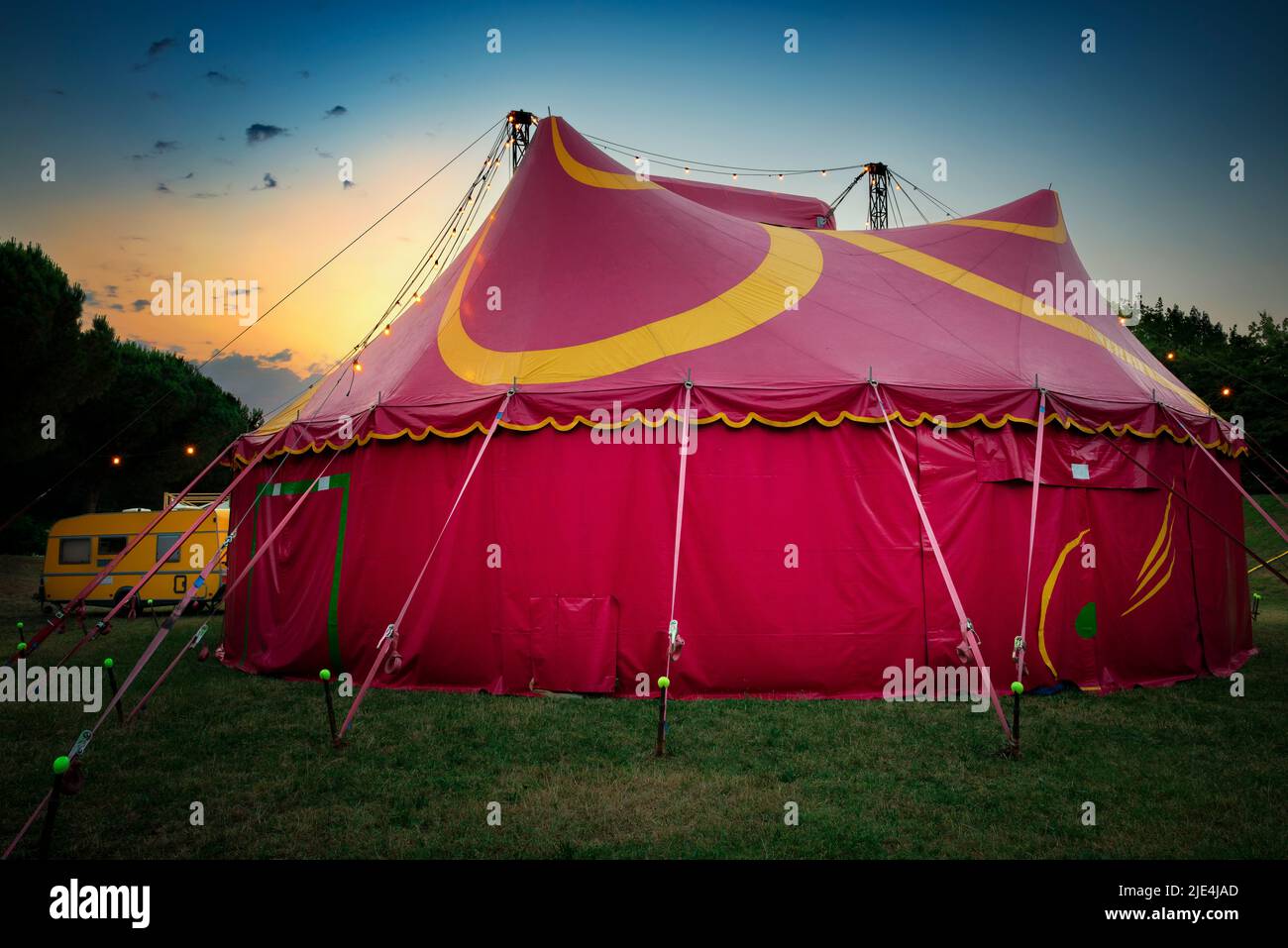 Dawn over a red an yellow circus tent mounted on a city park. Stock Photo