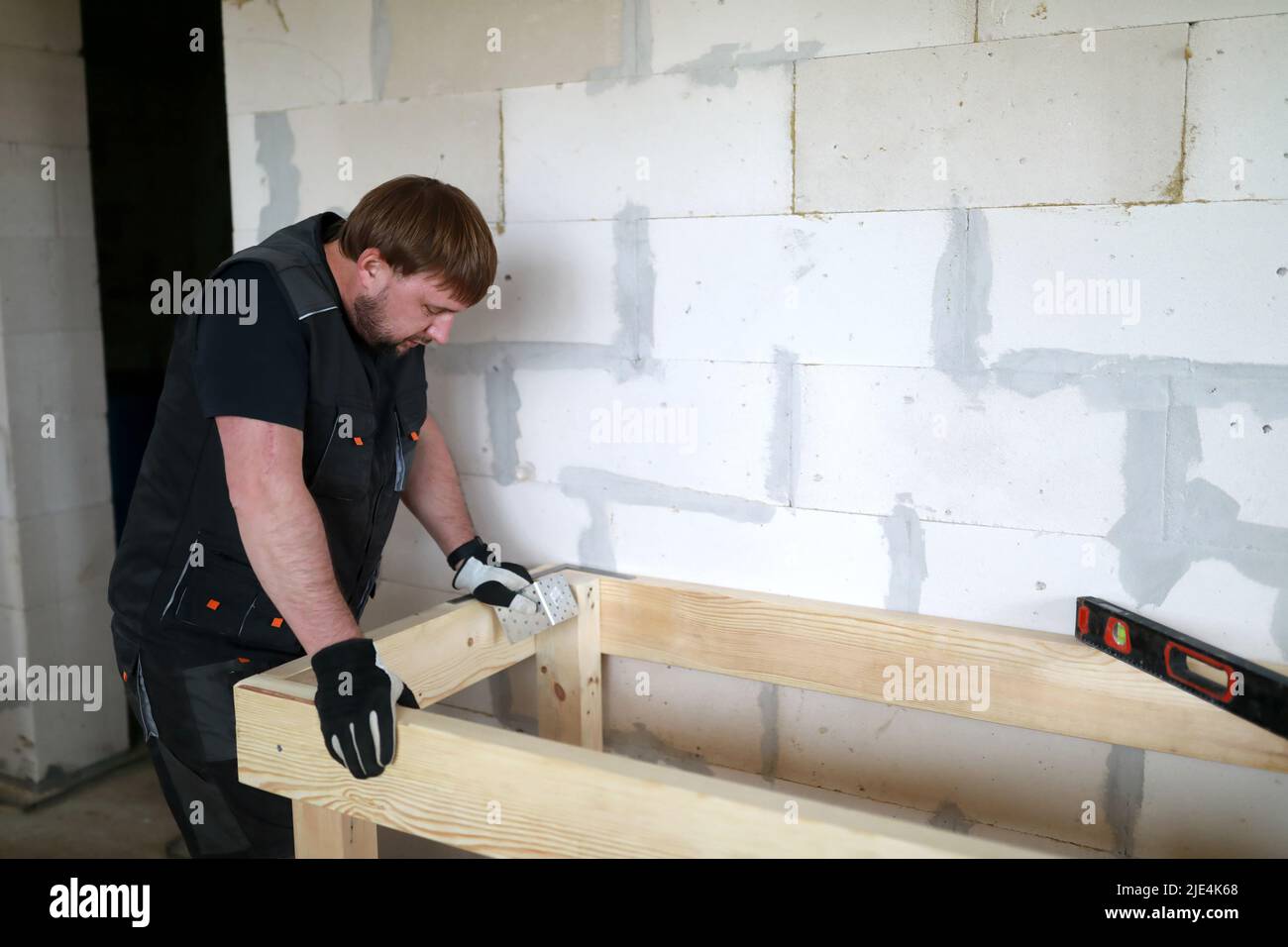 Man assembling table in building under construction Stock Photo