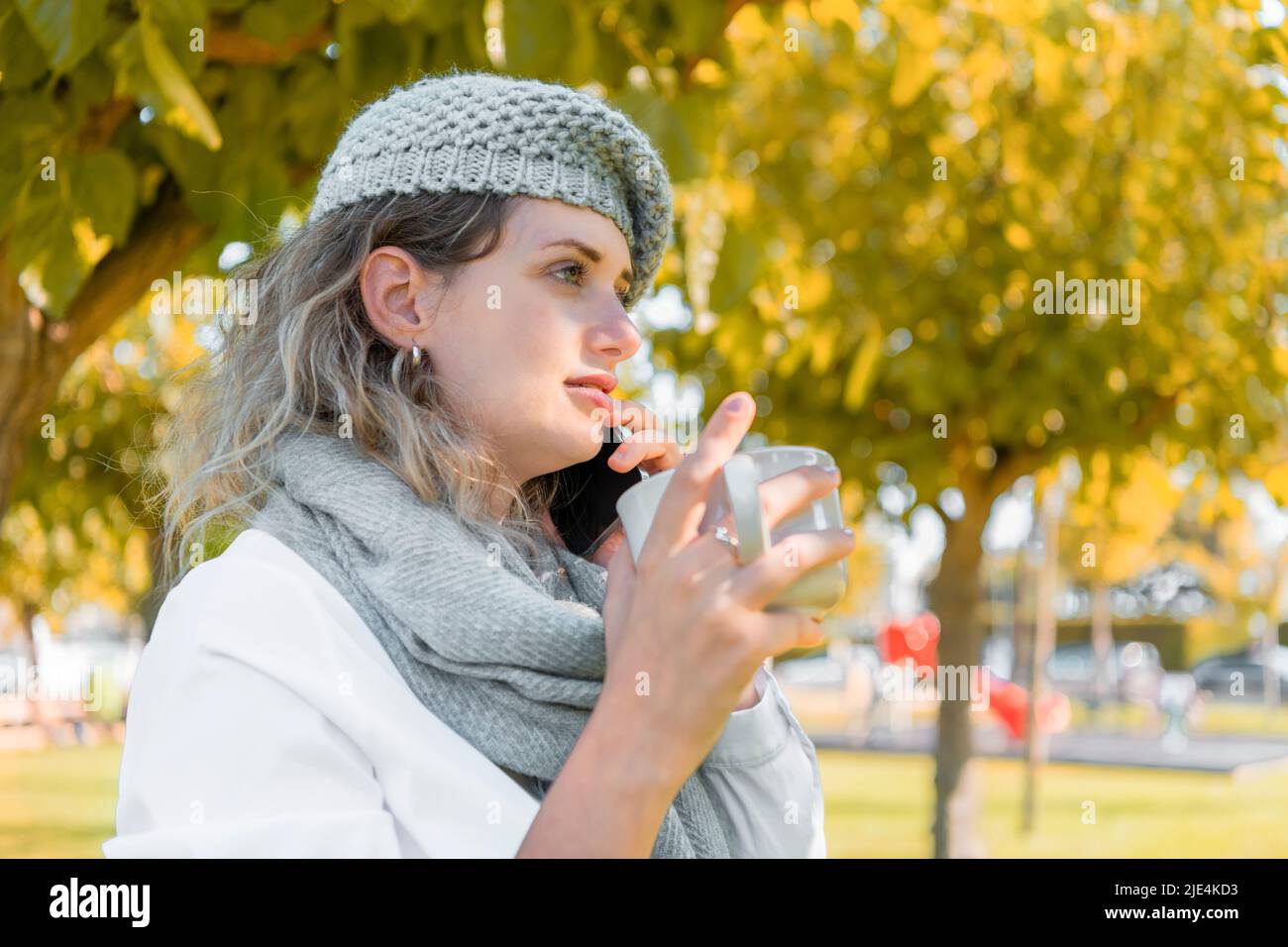 Young woman with a wool hat listening to her phone Stock Photo