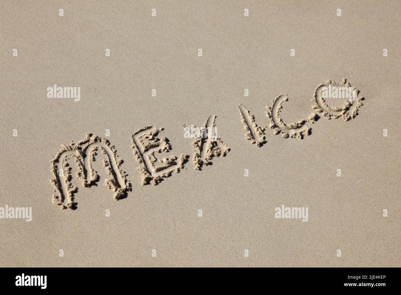 mexico written in the sand at the beach. Mexico's beaches are one of its tourist destinations. Stock Photo