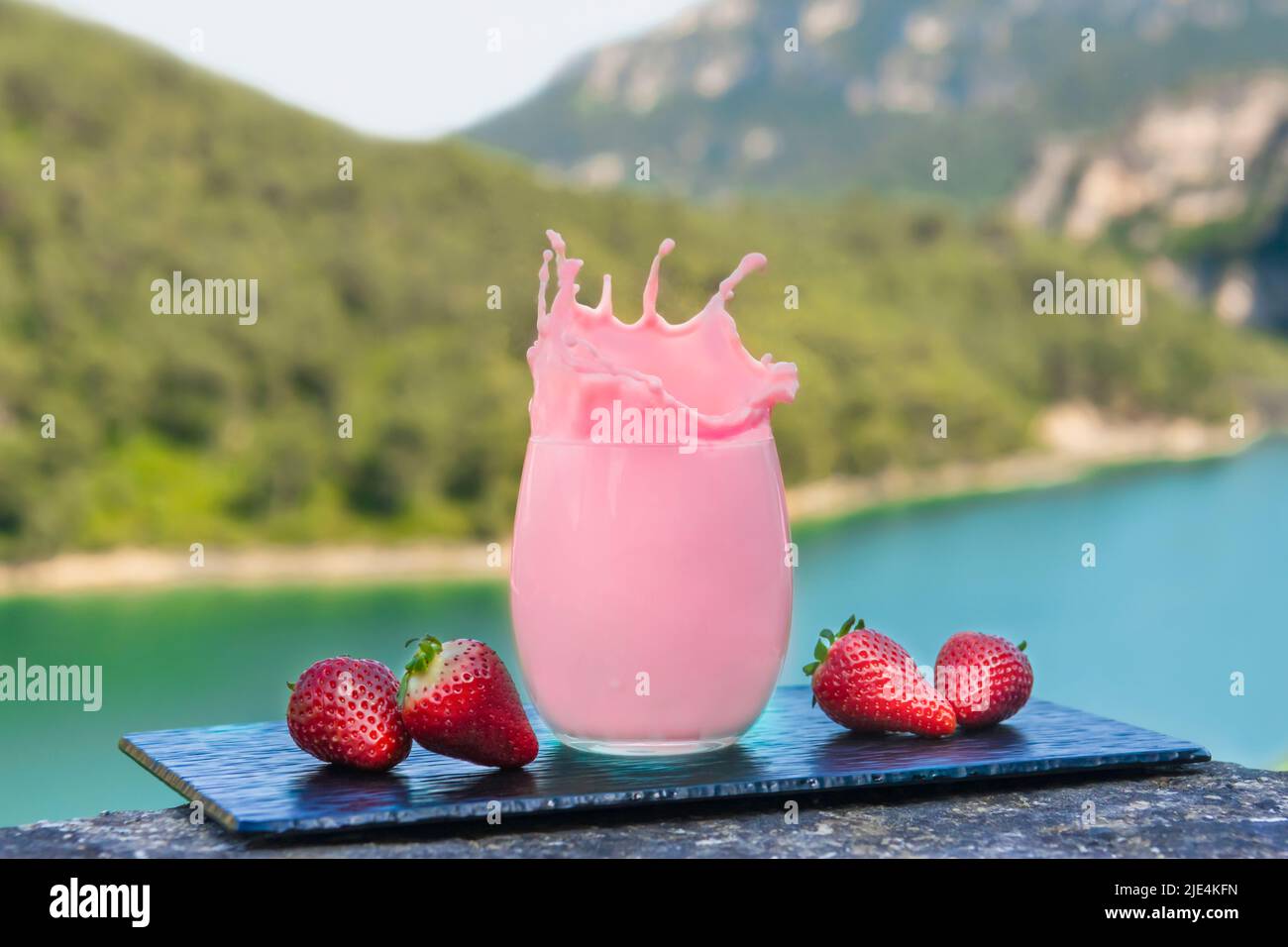 Close up of splashing strawberry shake with fresh strawberries Stock Photo