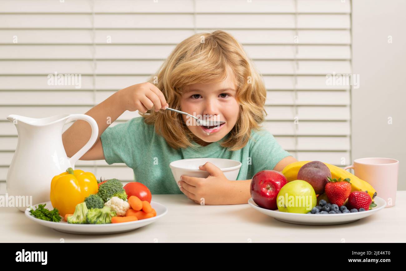 Morning snack with muesli cereal granola. Portrait of preteen child eat fresh healthy food in kitchen at home. Kid boy eating breakfast before school Stock Photo