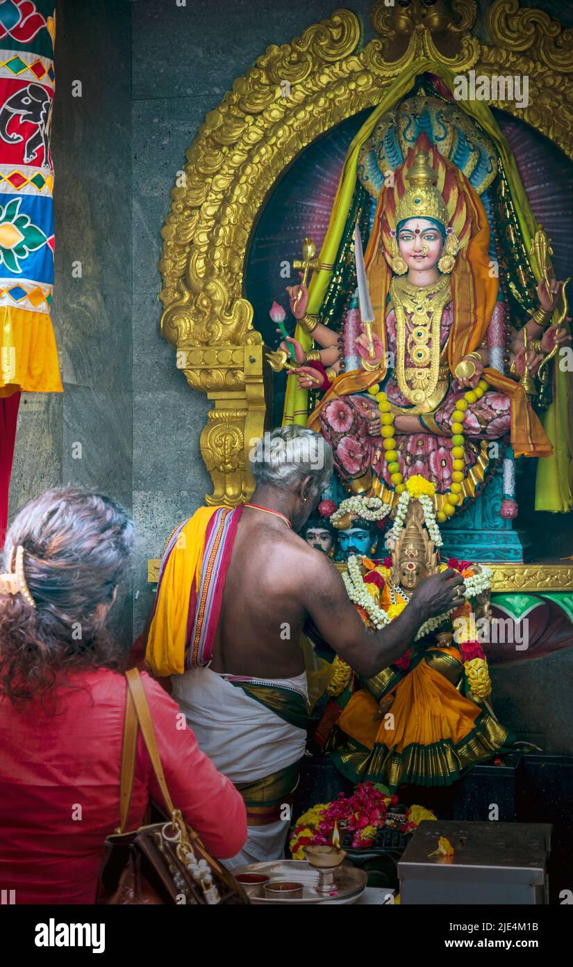 A priest and a worshipper in front of deities in the Sri Veeramakaliamman Temple, Serangoon Road, Little India, Republic of Singapore.  This Hindu tem Stock Photo