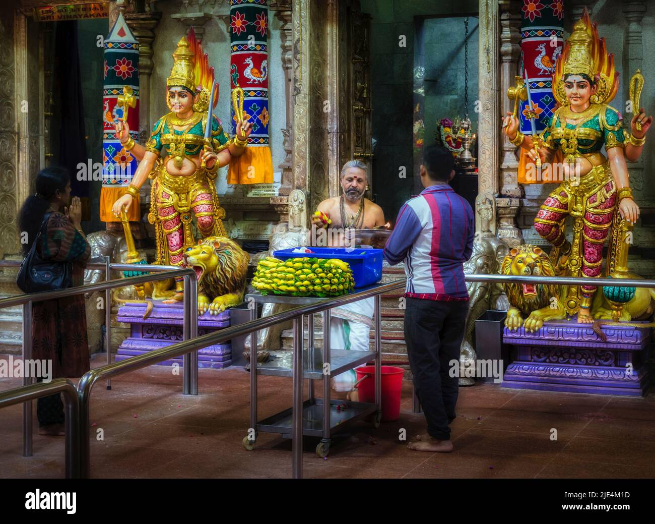 A priest and worshippers in the Sri Veeramakaliamman Temple, Serangoon Road, Little India, Republic of Singapore.  This Hindu temple is one of the old Stock Photo