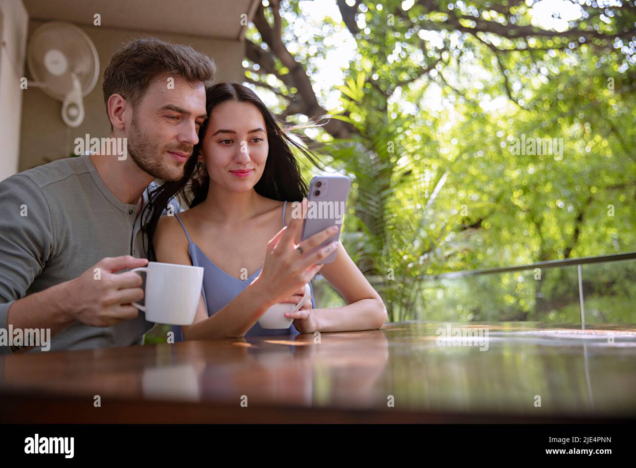 Couple chatting on mobile phone in the balcony  Stock Photo