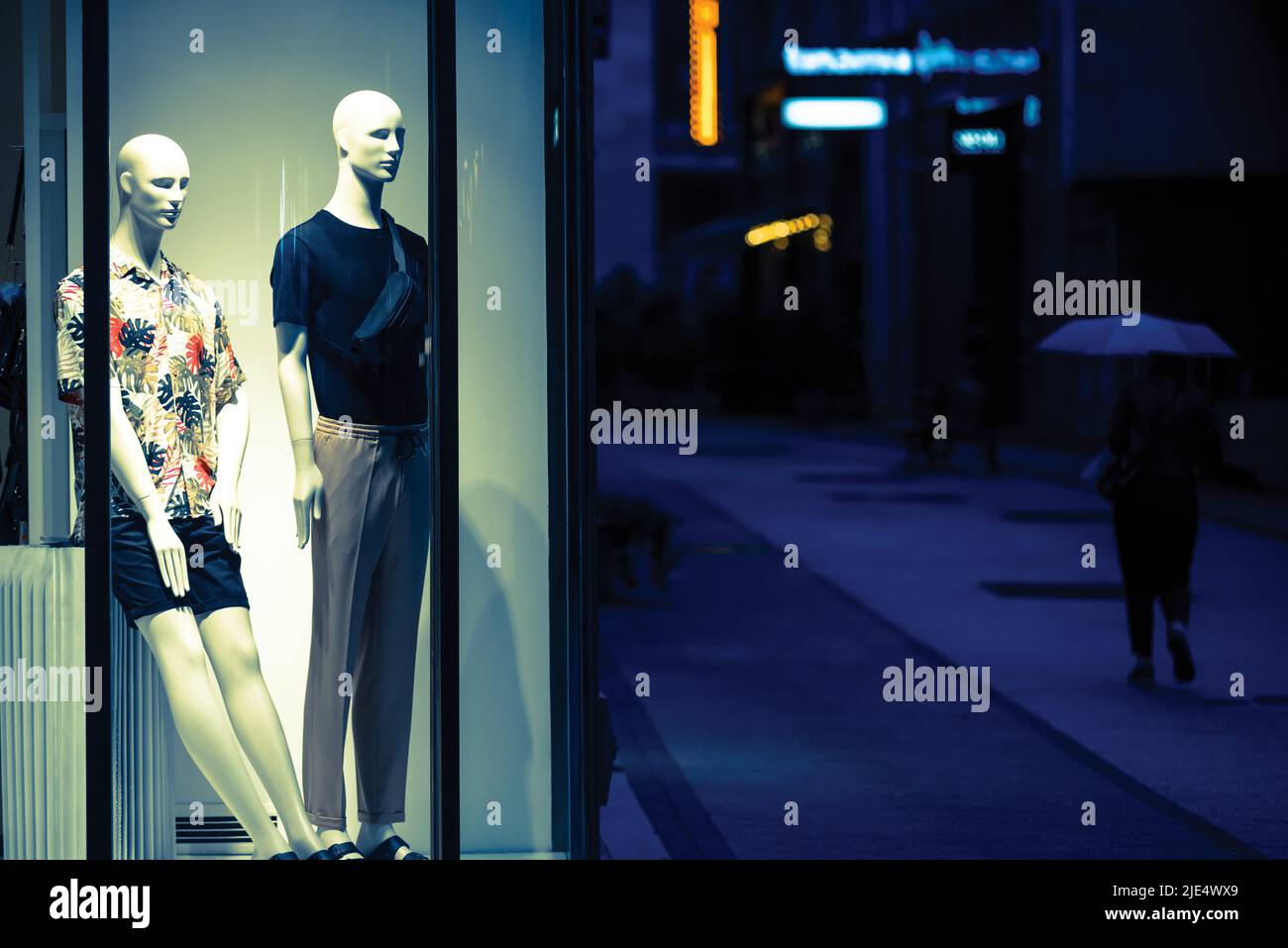 Two mannequins in a spotlight against night street Stock Photo