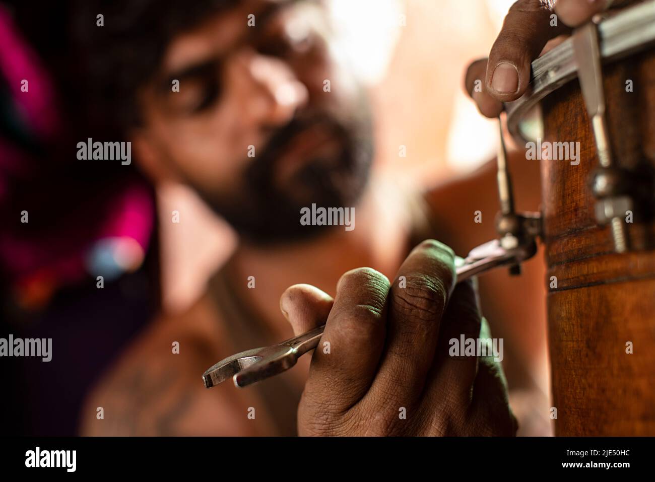 Closeup of a mid adult man repairing a drum at home Stock Photo