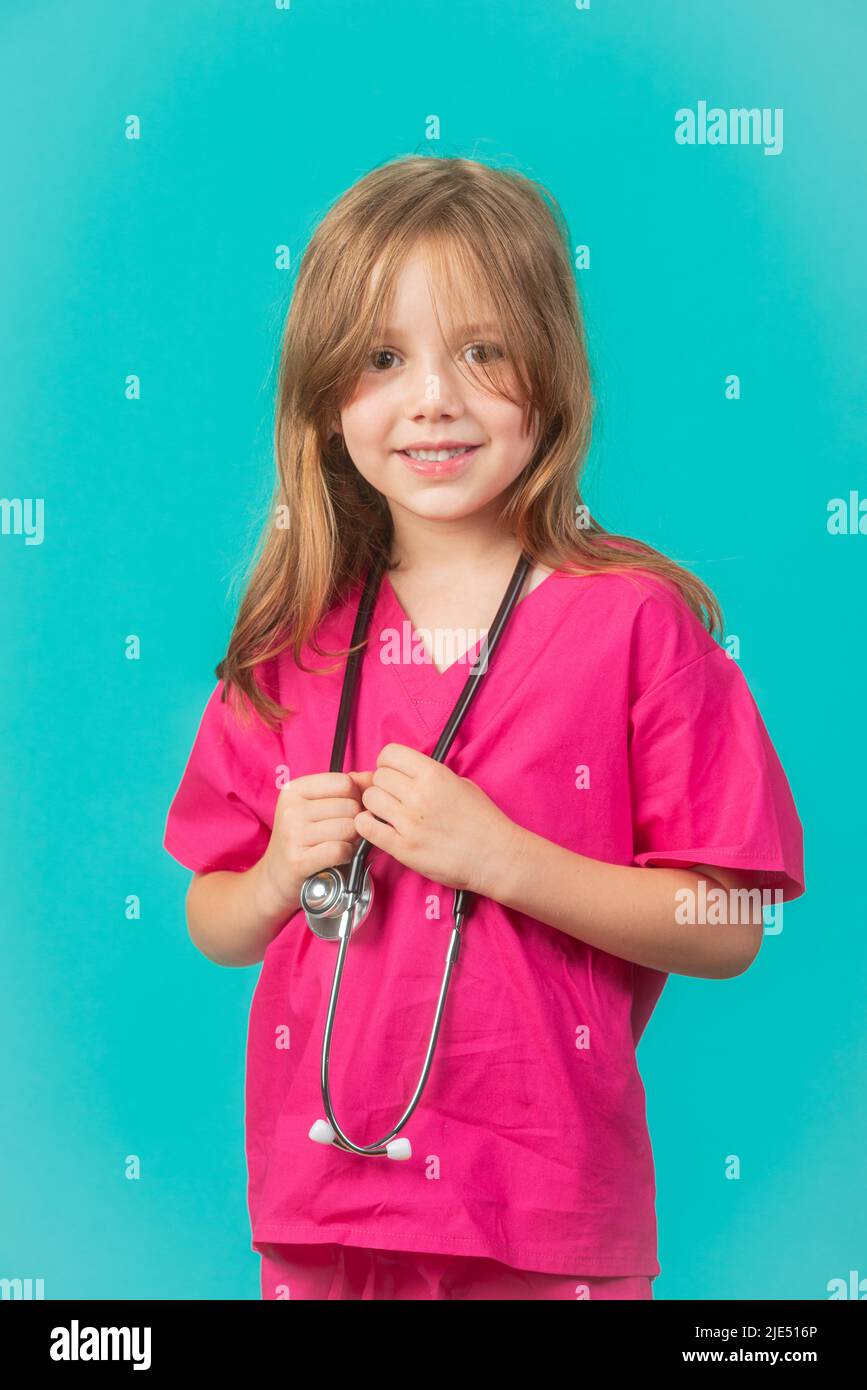 A 6-year-old girl is dressed as a doctor or nurse with a stethoscope around her neck. Feminism, STEM, and healthcare concepts. Stock Photo
