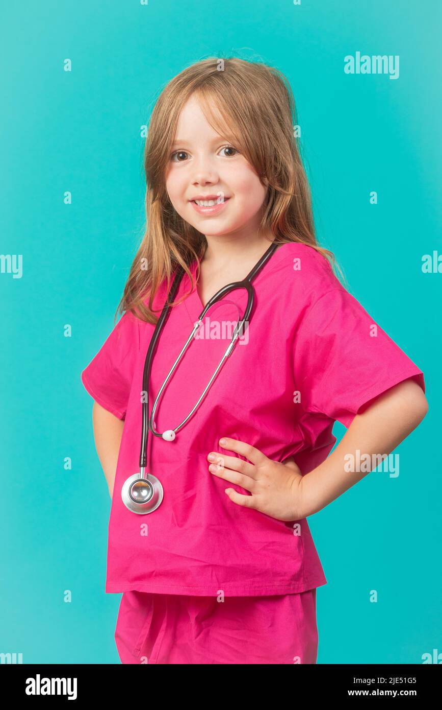 A 6-year-old girl is dressed as a doctor or nurse with a stethoscope around her neck. Feminism, STEM, and healthcare concepts. Stock Photo
