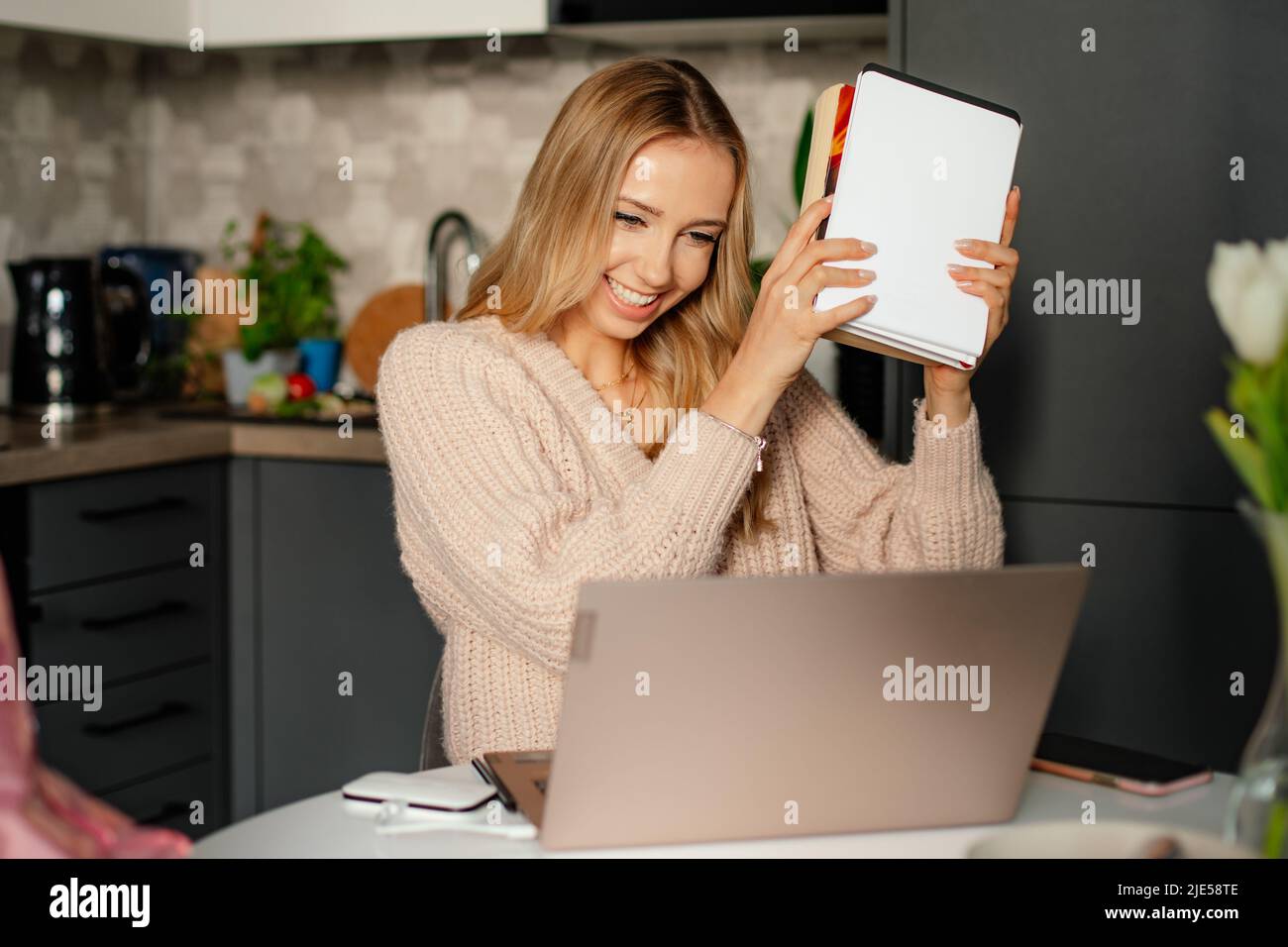 Young cute blonde person beautiful woman with books is happy to pass exams, online study, home office Stock Photo
