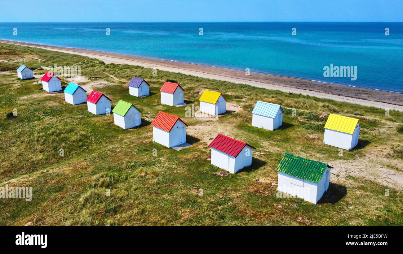 Aerial image of colourful beach huts, sand dunes and the sea at Gouville, France. Stock Photo