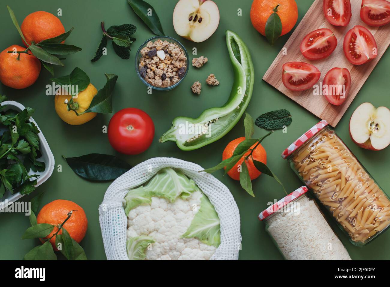 Flat lay with fresh local vegetables and fruits on green background. Plastic free, eco friendly concept. Idea of sustainable living, conscious consump Stock Photo