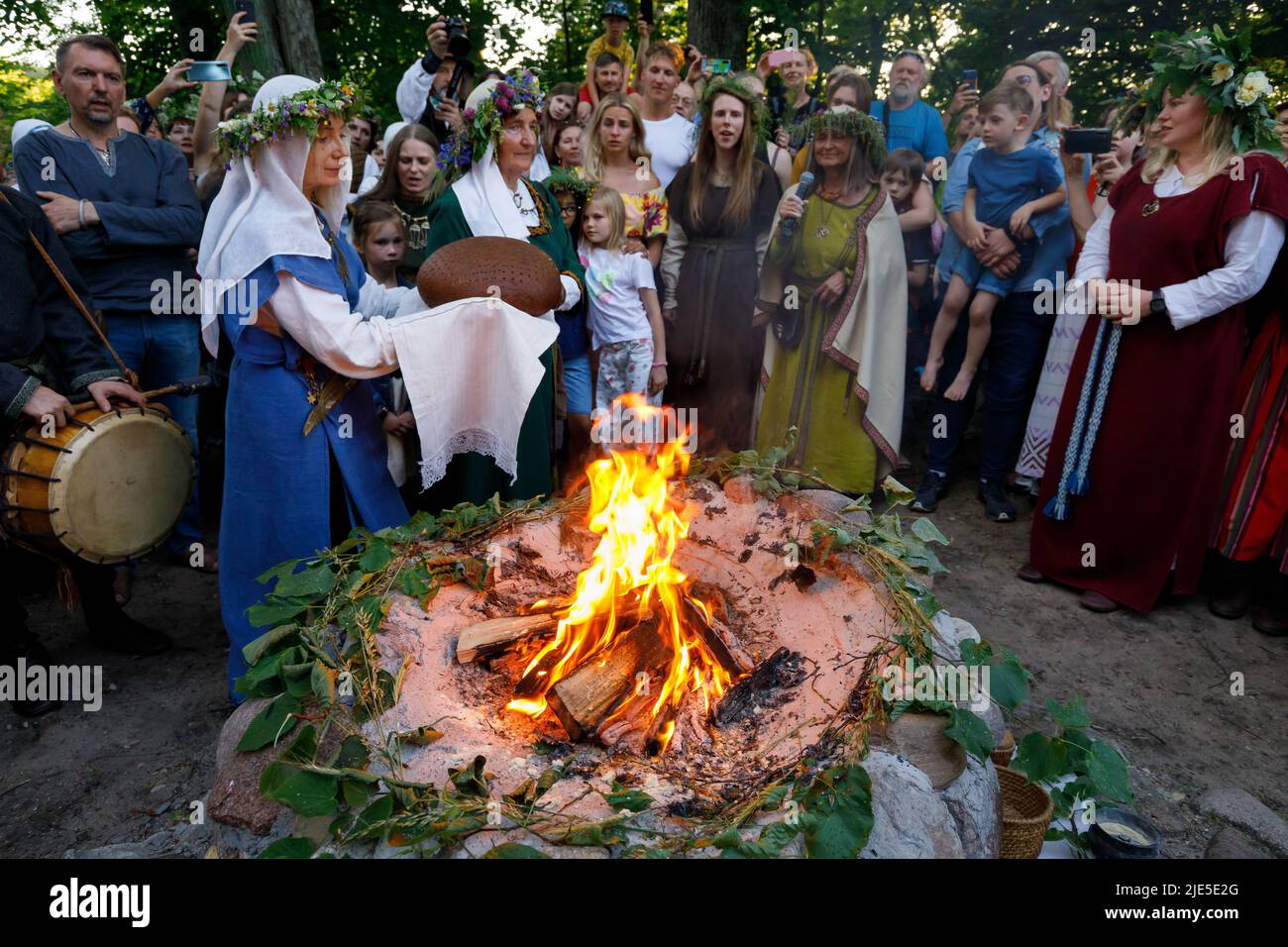 Women in Lithuanian national costumes perform rituals with freshly baked rye bread, during the celebration Midsummer Festival in Vilnius Stock Photo