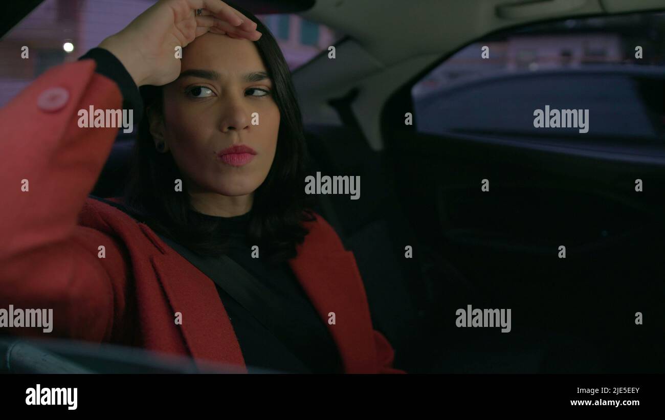 Stressed young woman sitting in the backseat of car commuting in ...