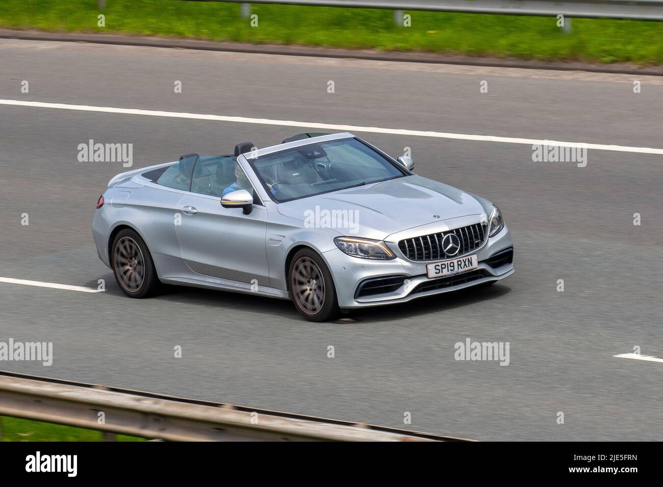 2019 silver Mercedes Benz 3982cc petrol Cabrio, Amg C 63 Auto C63 Speedshift MCT Auto start-stop cabriolet;  traveling on the M6 motorway, UK Stock Photo
