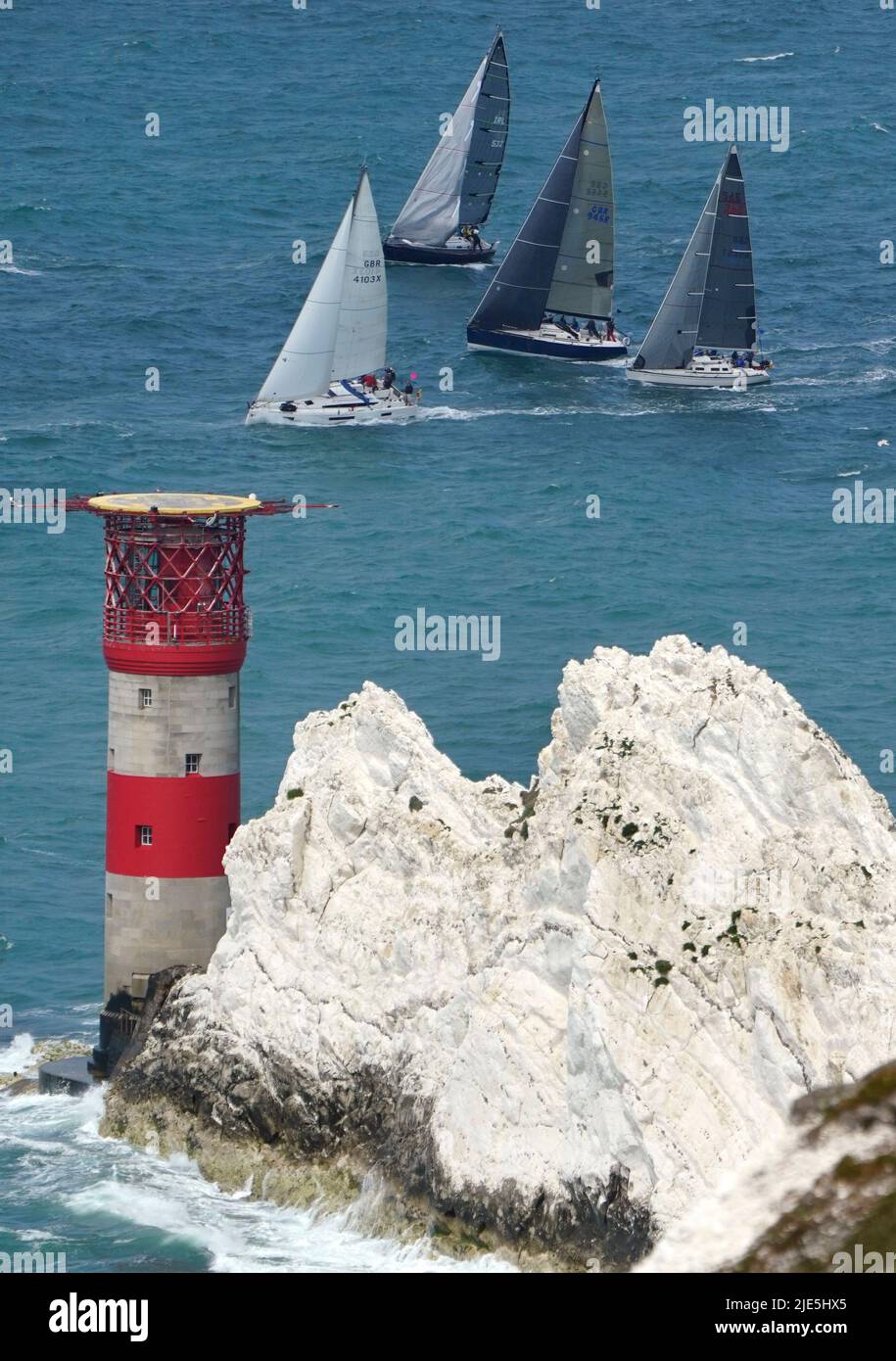 Sailing boats pass The Needles, as they take part in the annual Round the Island Race, a one-day, 50 nautical mile yacht race around the Isle of Wight. Starting on the famous Royal Yacht Squadron line in Cowes, the fleet are racing westabout, to The Needles, round St Catherine's Point and Bembridge Ledge buoy, and back into the Solent to the finish line at Cowes. Picture date: Saturday June 25, 2022. Stock Photo