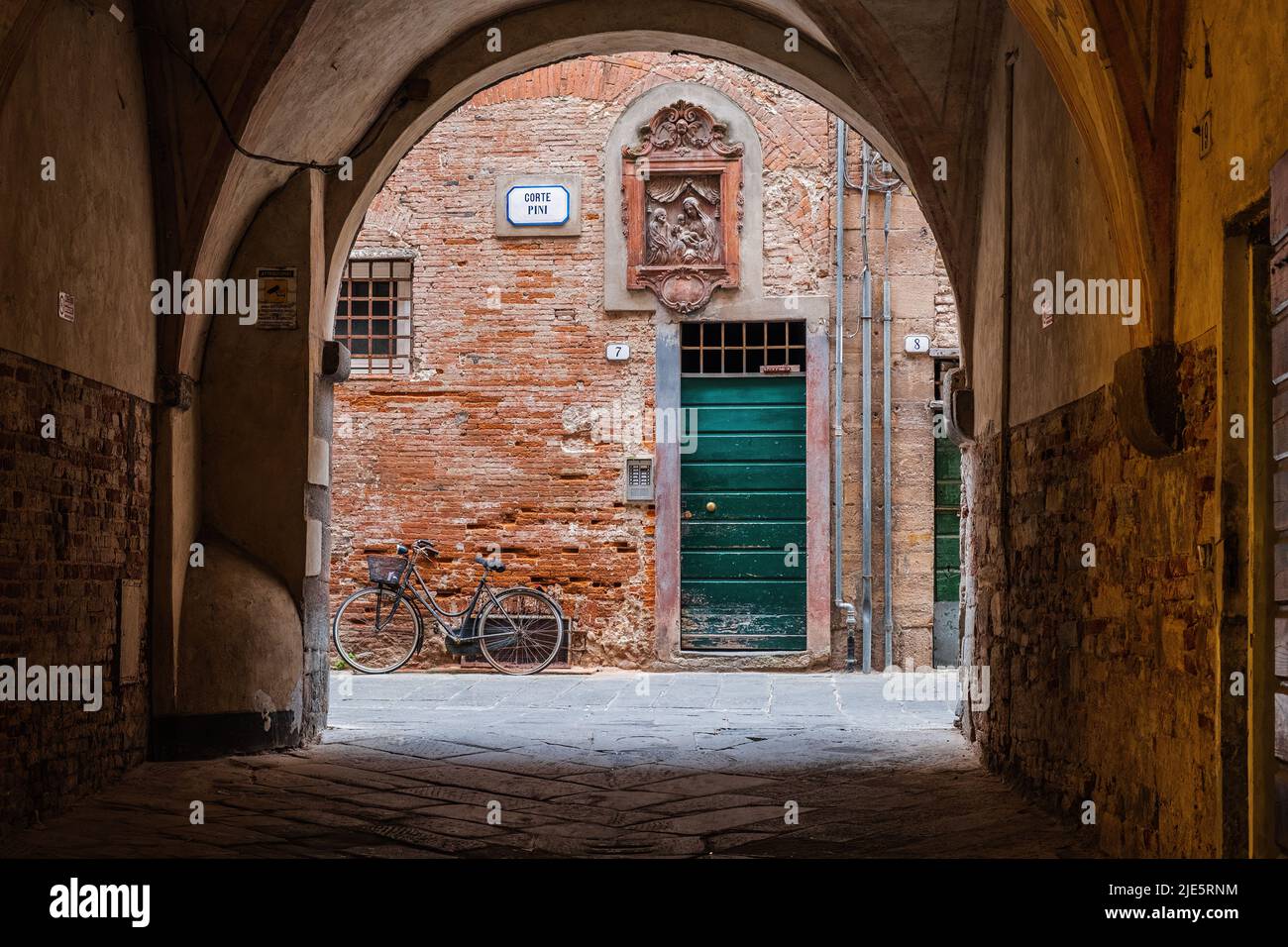 Lucca, Italy - 6/8/2022: Bicycle at rest in traditional Tuscan courtyard in Lucca, Italy. Stock Photo