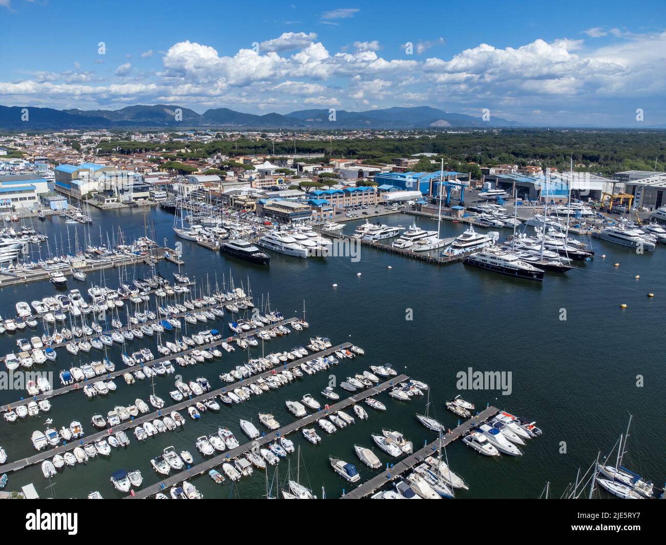 Drone view of many boats moored at Viareggio, Italy with mountains and dramatic clouds. Stock Photo