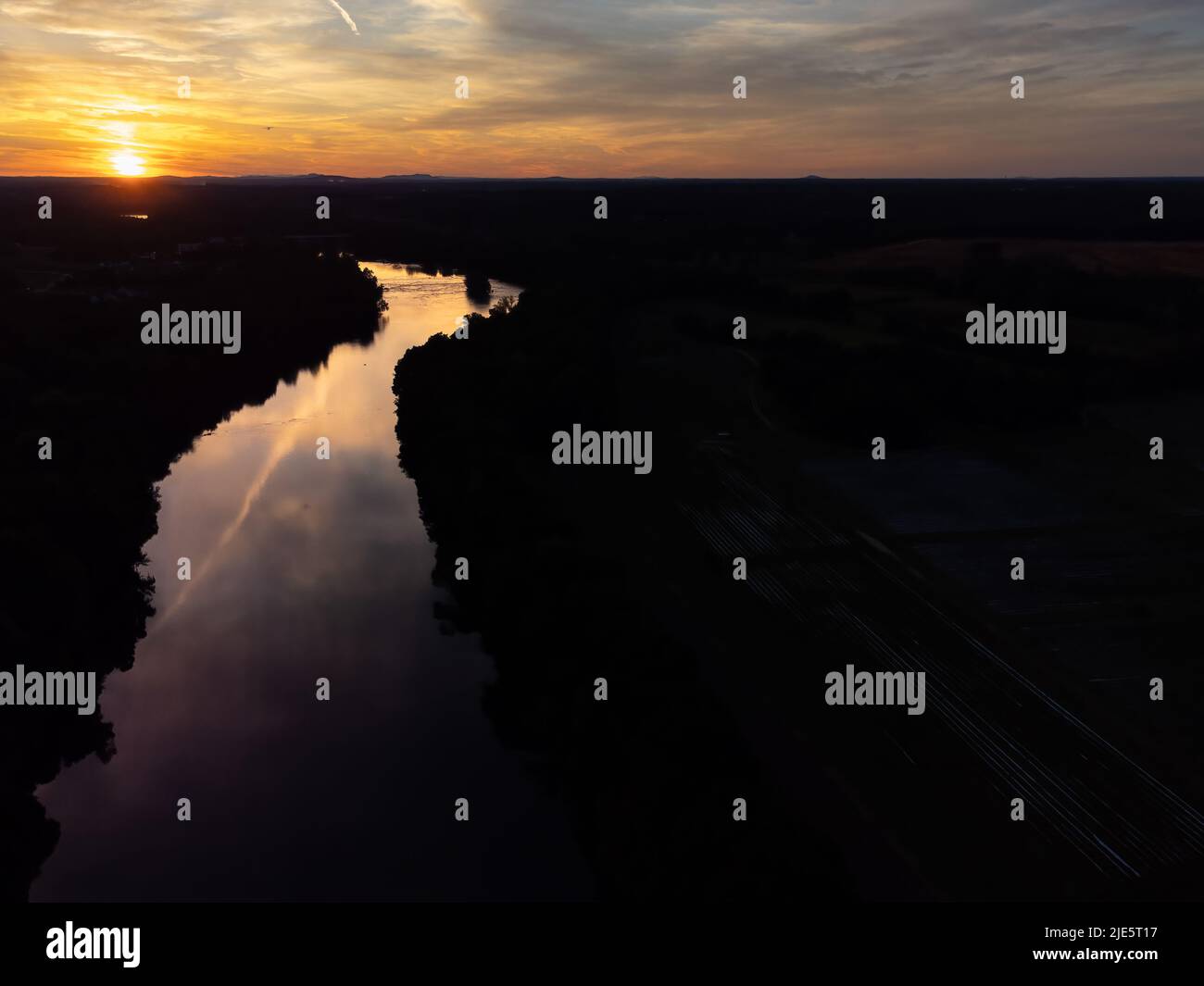 Aerial view of dramatic sunset reflecting on calm river with negative space for copy. Stock Photo