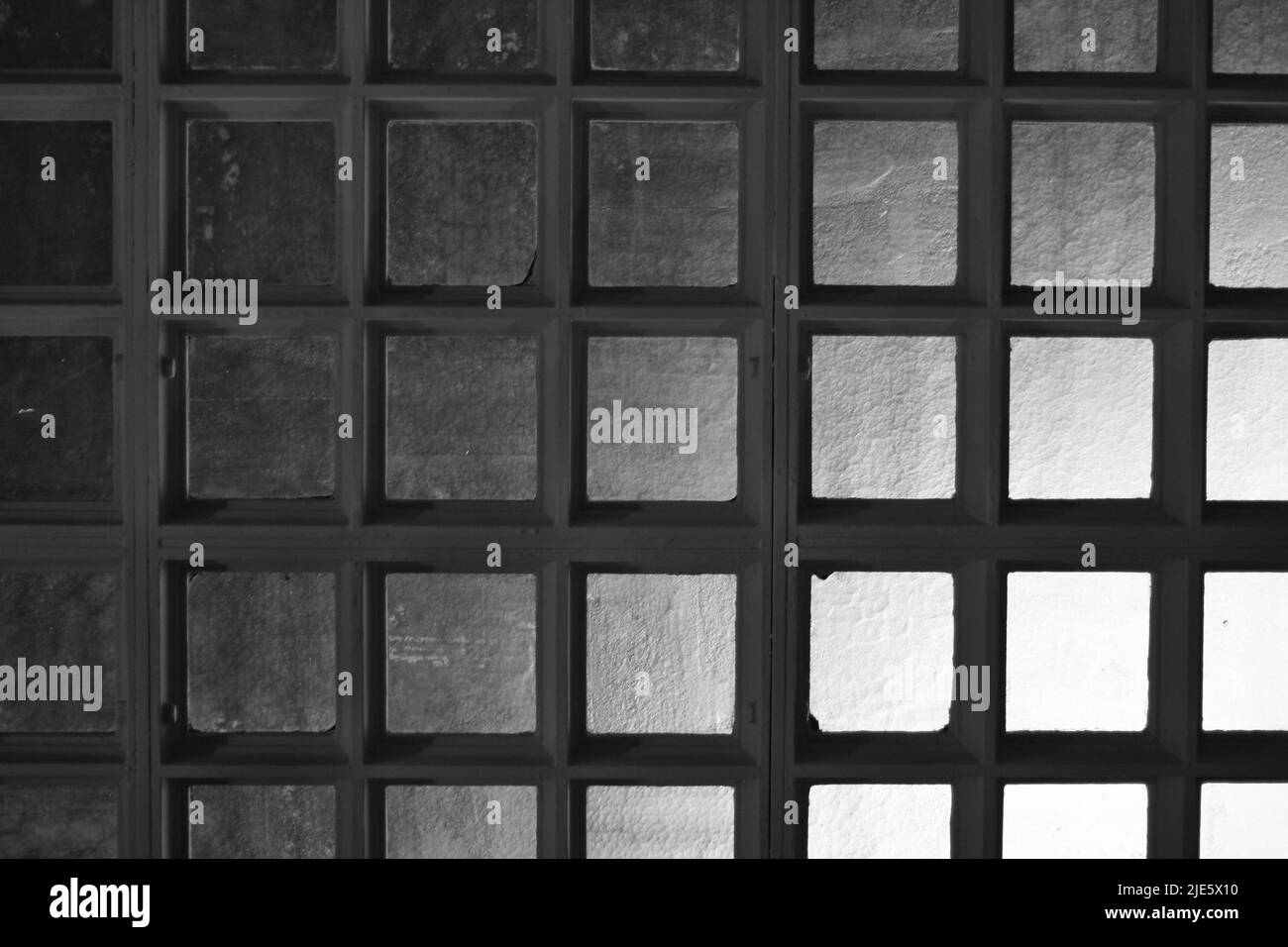 Square glass tile with a light illuminating the background in black and ...