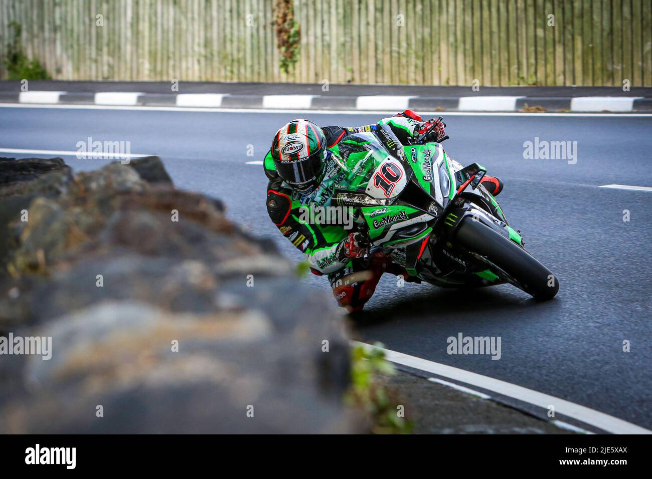 Peter Hickman on the Gas Monkey Garage by FHO Racing BMW S1000RR superbike at the 2022 Isle of Man TT races cornering next to a manx stone wall. Stock Photo
