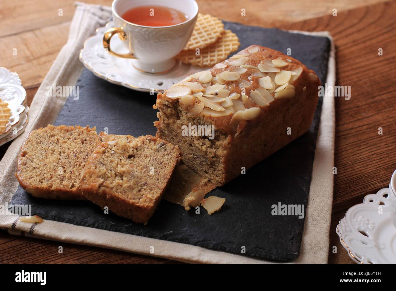 Loaf Banana Nut Sweet Bread Sliced on a Slate Plate, Served with Tea