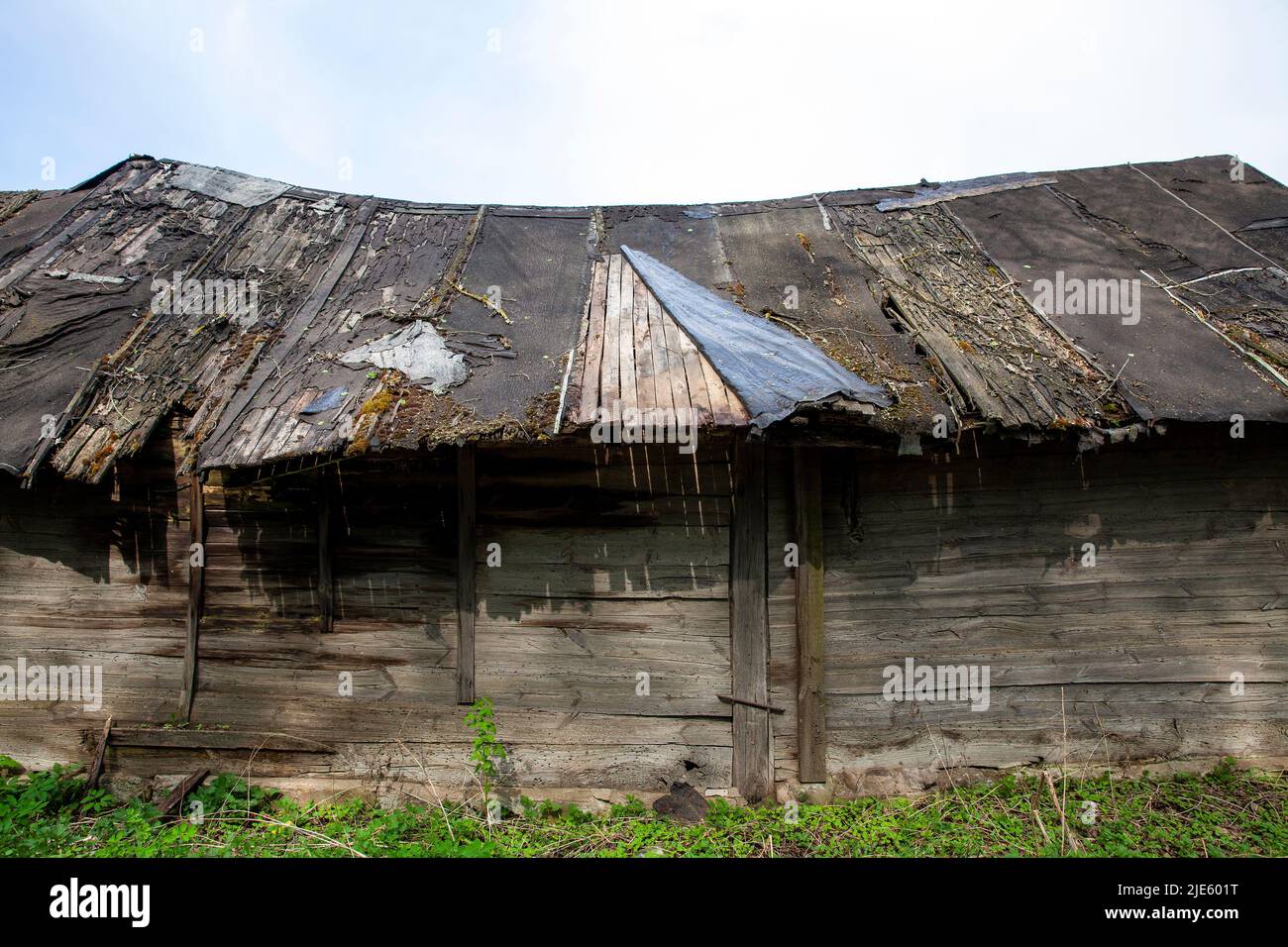 an old wooden shed with a broken roof, a broken old building made of