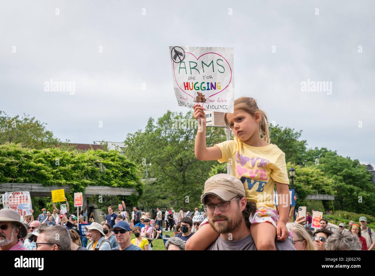 Young girl on her father's shoulders hold protest sign March for Our ...