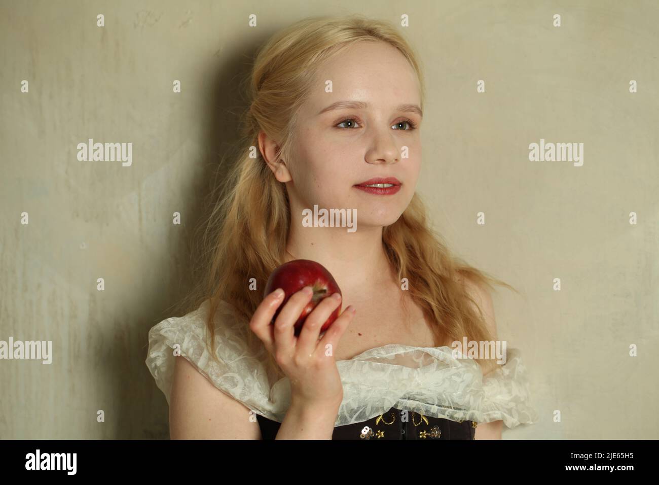 Portrait of young blonde woman with red apple close up Stock Photo