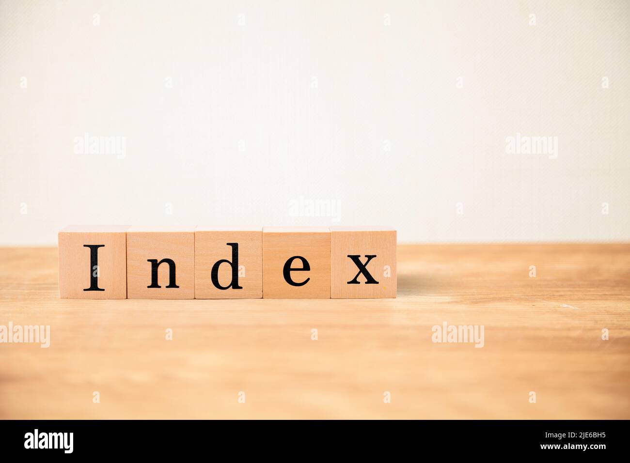 Index character. index. Written on five wooden blocks. Black letters. Wooden table and white wall background. Stock Photo