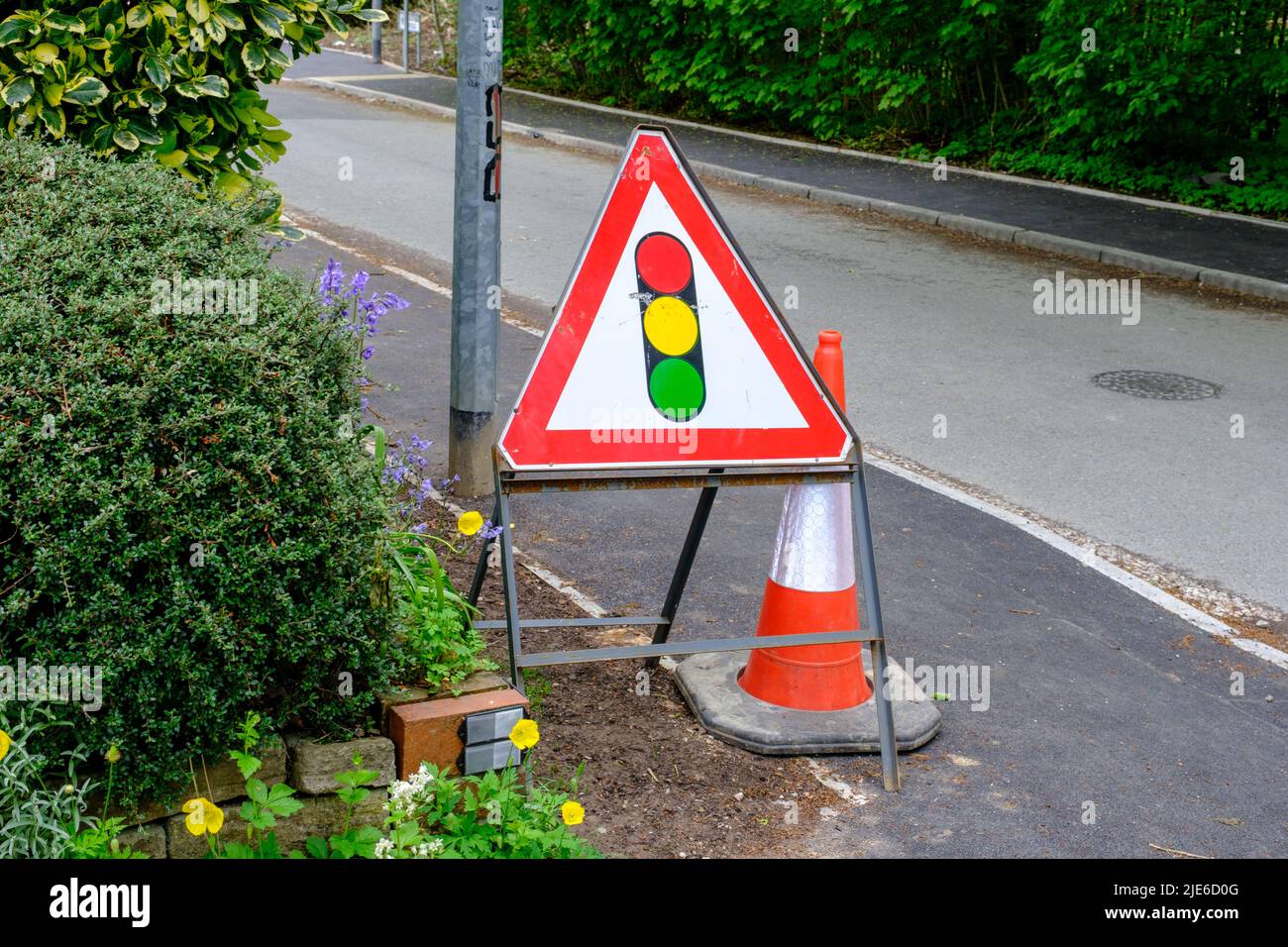 Traffic lights warning triangle sign on road in UK Stock Photo