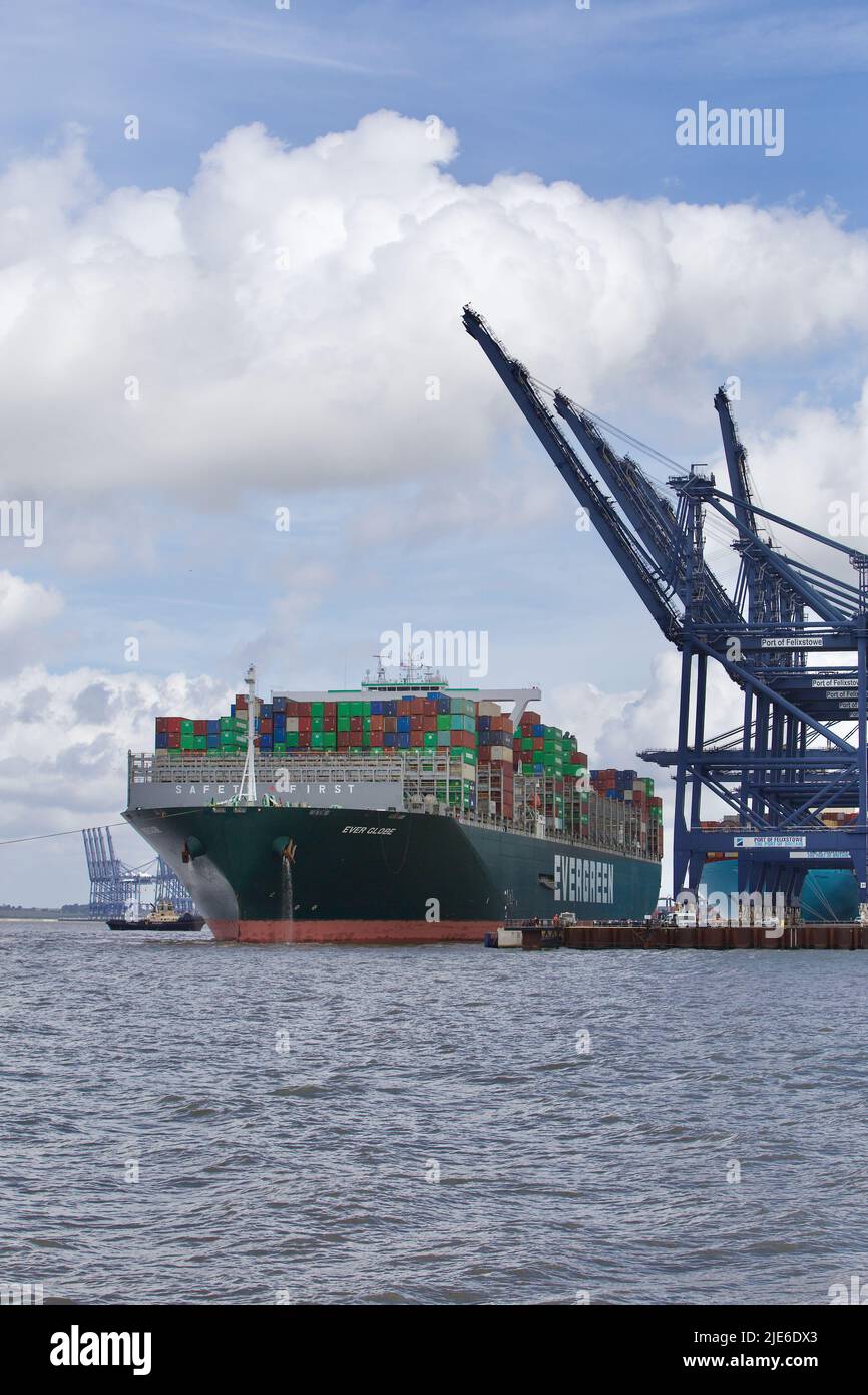 Evergreen Container ship Ever Globe docking at the Port of Felixstowe assisted by tugboats. Stock Photo