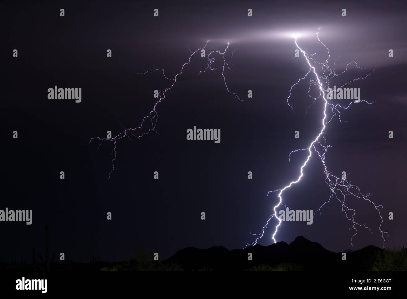 Cloud to ground lightning strikes a mountain during a monsoon thunderstorm near Morristown, Arizona, USA Stock Photo