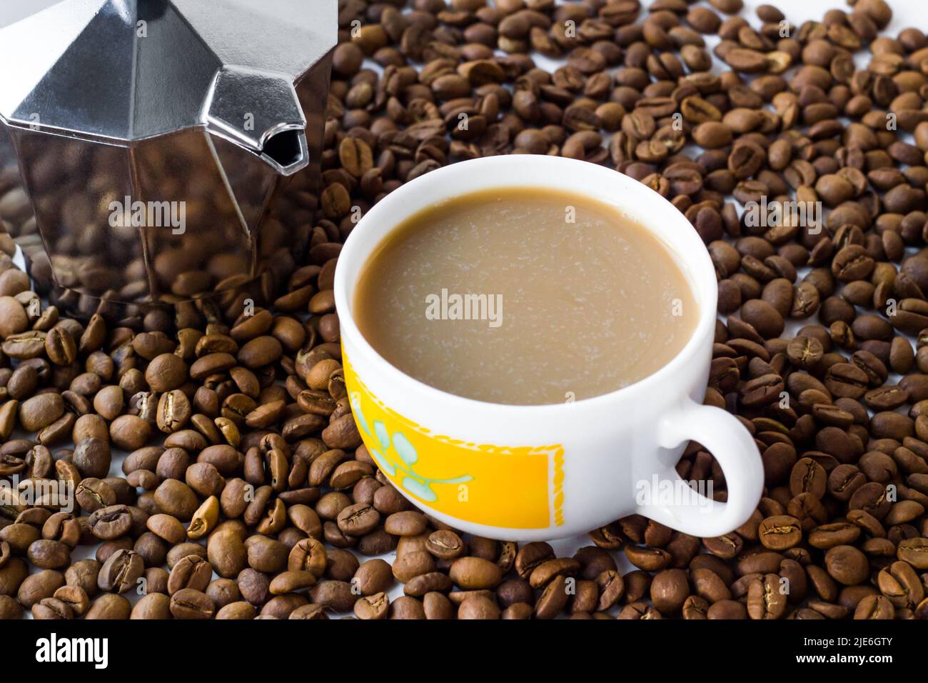 Traditional italian metal coffee maker with coffee beans and coffee