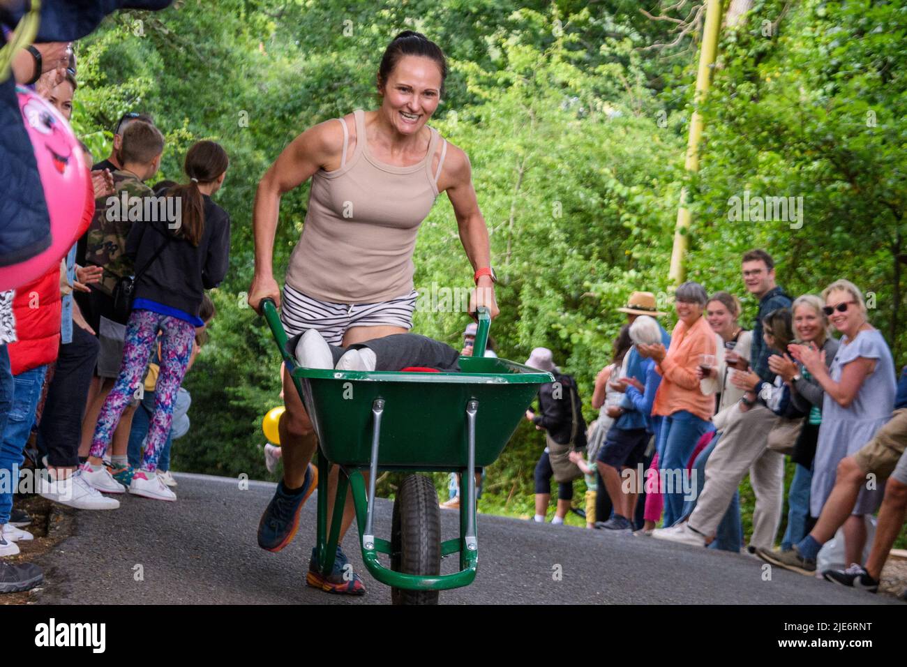 New Forest, Hampshire, UK, 25th June 2022: A competitor feels the pain in the wheelbarrow race at Frogham Fair, Frogham, Fordingbridge. The physically demanding timed races take place up Blissford Hill which has a 1 in 4 incline. Credit: Paul Biggins/Alamy Live News Stock Photo