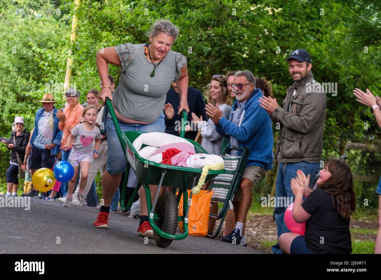 New Forest, Hampshire, UK, 25th June 2022: A competitor feels the pain in the wheelbarrow race at Frogham Fair, Frogham, Fordingbridge. The physically demanding timed races take place up Blissford Hill which has a 1 in 4 incline. Credit: Paul Biggins/Alamy Live News Stock Photo