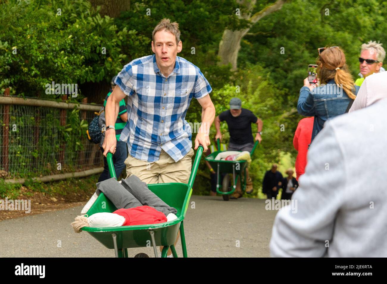 New Forest, Hampshire, UK, 25th June 2022: Competitors feel the pain in the wheelbarrow race at Frogham Fair, Frogham, Fordingbridge. The physically demanding timed races take place up Blissford Hill which has a 1 in 4 incline. Credit: Paul Biggins/Alamy Live News Stock Photo