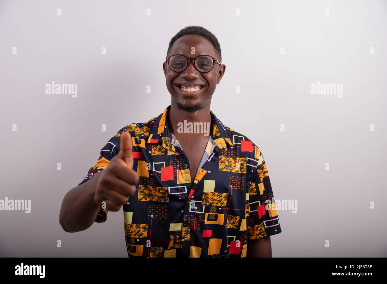 Happy smiling boy in photo studio raises thumb in victory sign. Thumb up. Stock Photo
