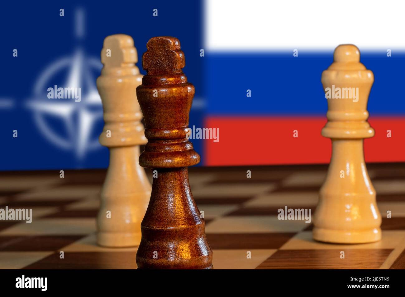 Symbolbild: Pattsituation im Schach mit den Flaggen der Nato und von Russland im Hintergrund Stock Photo