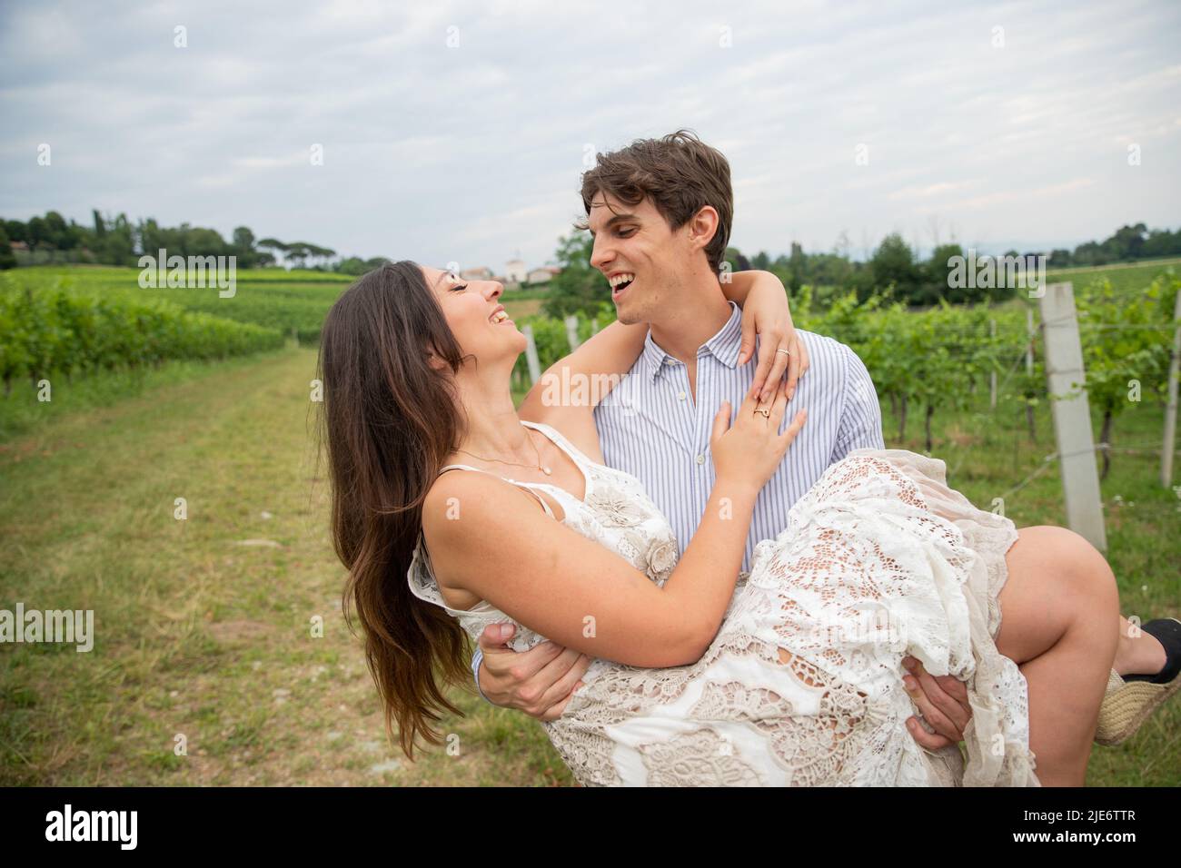 Girl in love gets picked up by her love in an outdoor field. Love concept. Stock Photo