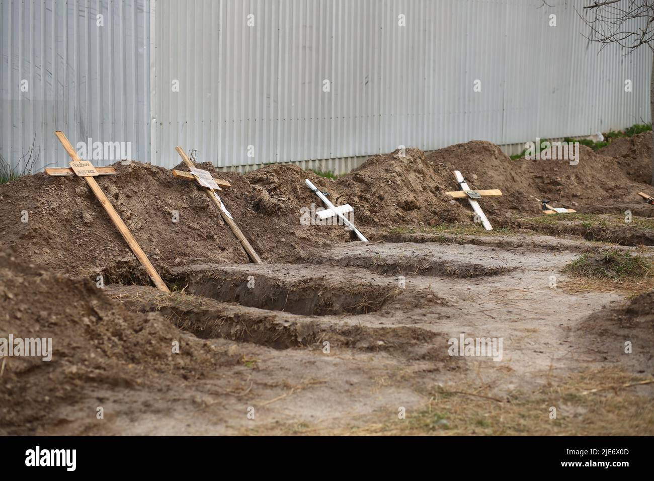 Bucha, Ukraine - April 12, 2022: Empty graves of the killed by the russian army civilans, buried by their neighbors in home yard, after exhumation of Stock Photo