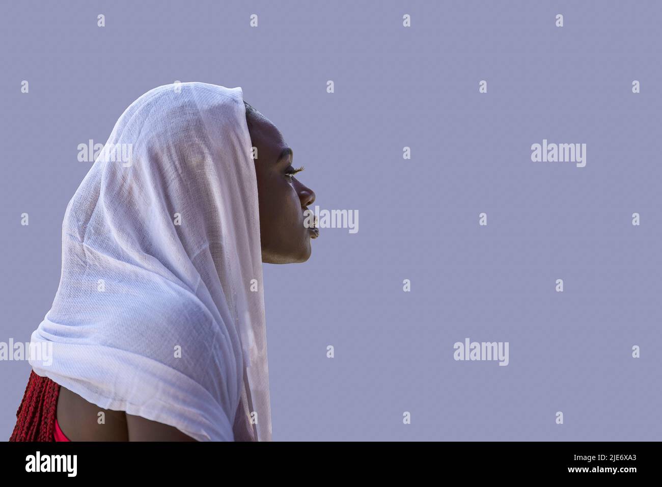African Ghana woman standing with a white shawl covering her hair Stock Photo