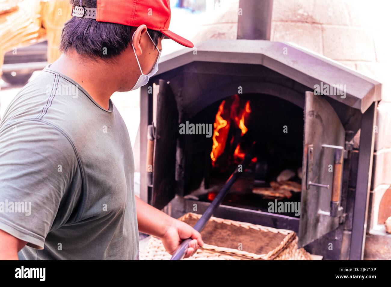 Baker baking bread in a clay oven Stock Photo