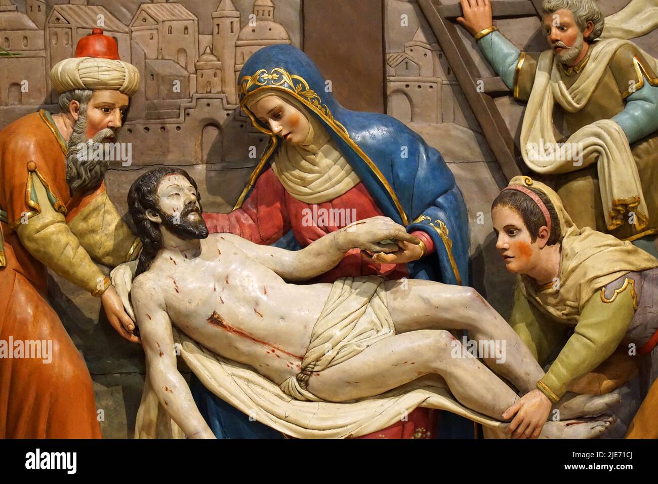 The Descent of Christ from the cross in painted relief . Stock Photo
