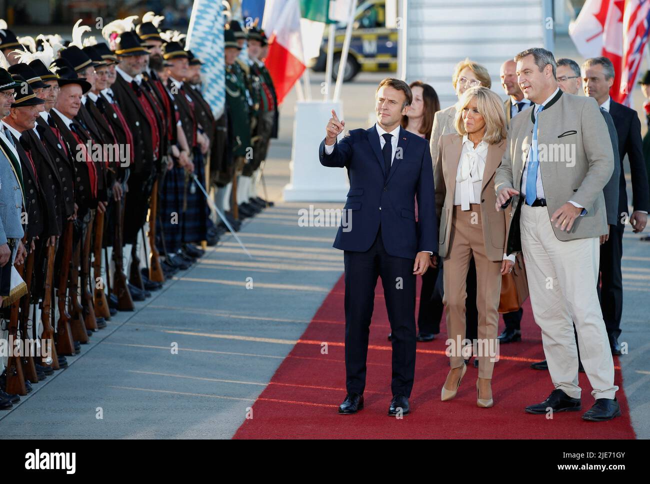 French President Emmanuel Macron and his wife Brigitte Macron are greeted by Bavaria's State Premier Markus Soeder upon their arrival at Franz-Josef-Strauss airport in Munich ahead of the G7 summit, which will take place in the Bavarian alpine resort of Elmau Castle, Germany, June 25, 2022. REUTERS/Michaela Rehle Stock Photo
