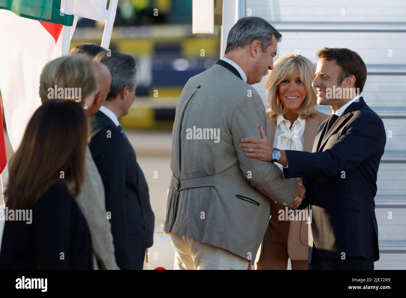 French President Emmanuel Macron and his wife Brigitte Macron are greeted by Bavaria's State Premier Markus Soeder upon their arrival at Franz-Josef-Strauss airport in Munich ahead of the G7 summit, which will take place in the Bavarian alpine resort of Elmau Castle, Germany, June 25, 2022. REUTERS/Michaela Rehle Stock Photo