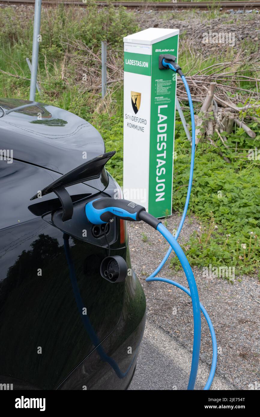 Stokke, Norway - May 25, 2022: A static shot of a solid black Tesla Model 3 dual motor charging at the Sandefjord municipality AC charging station Stock Photo