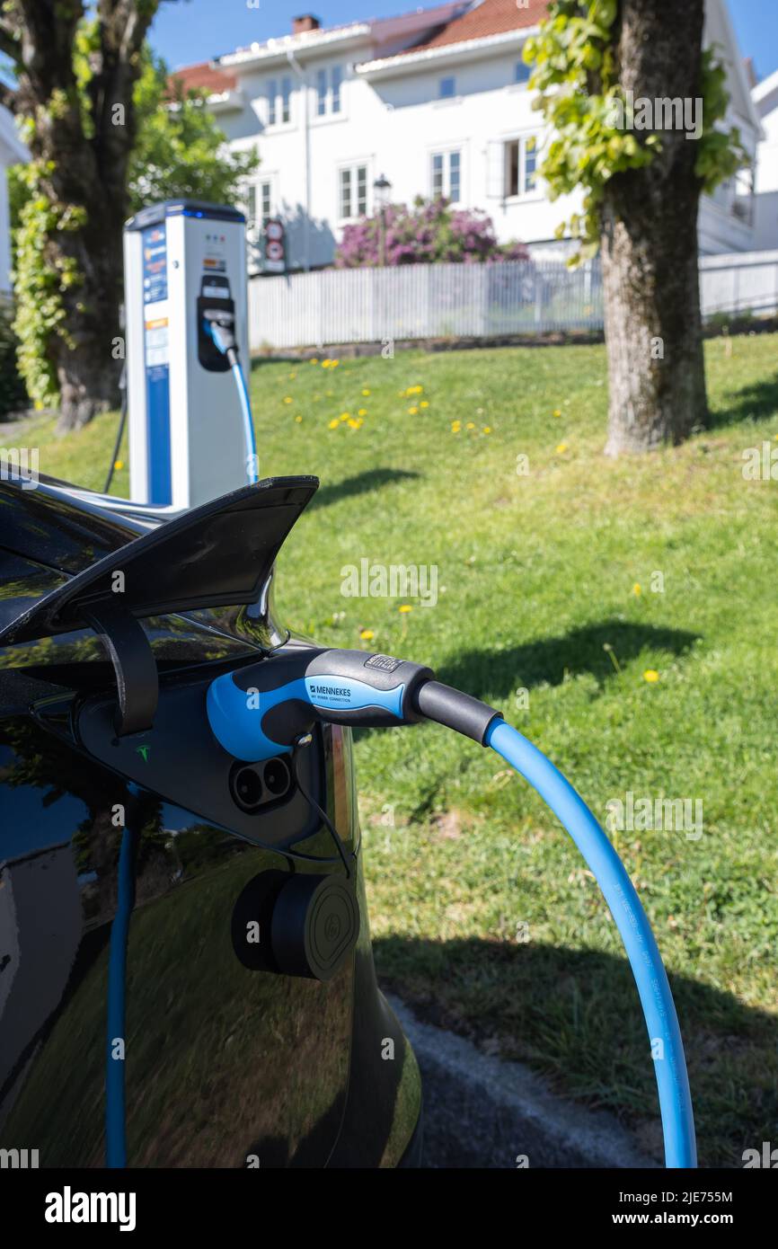 Brevik, Norway - May 26, 2022: A static shot of a solid black Tesla Model 3 dual motor charging at the Recharge AC charging station Stock Photo