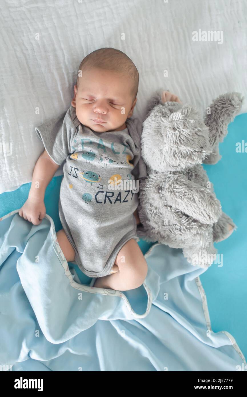Cute little peaceful baby calm sleeps soundly in his crib with his baby